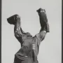 The Destroyed City sculpture, with an abstract figure raising its arms and a void through the torso, partially covered by cloth on a stone pedestal.