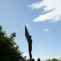 The Angel of the North sculpture standing on a grassy hill against a cloudy sky.