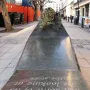 A Conversation with Oscar Wilde granite monument with a bronze bust holding a cigarette.