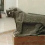 Stone lion sculpture with open mouth and carved symbols on its front
