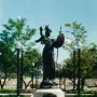 Russell Alger Memorial Fountain with a helmeted female figure holding a shield and sword atop a stone pedestal in a fountain basin.