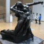 The Eternal Springtime bronze sculpture of a man embracing a woman, displayed on a pedestal in a museum gallery.
