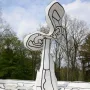 Jardin d\'émail sculpture with white abstract forms, black outlines, and tiered steps against trees and a cloudy sky.