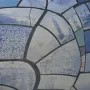 Close-up of the Big Fish sculpture’s blue and white mosaic scales with illustrations and text fragments
