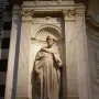 White marble statue of Saint Peter in the Piccolomini Altar at Siena Cathedral, shown in a twisting pose with a book held in his left arm.