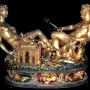 Cellini Salt Cellar with a reclining female figure and a seated male figure holding a trident on a detailed golden base.