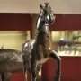 Bronze horse statue from the Neuvy-en-Sullias Hoard, shown with one front leg raised on a rectangular base.
