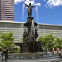Tyler Davidson Fountain with a robed figure and smaller bronze figures in a city plaza