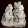 The Confidence marble sculpture showing four seated women in two facing pairs against a dark background.