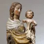 Friesentor Madonna, a polychrome sculpture of a woman holding a child with rosy cheeks and flowing hair.