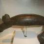 The Alunda Moose stone sculpture displayed on a clear stand with a white base.