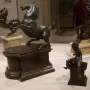 Bronze rearing horse sculpture beside a smaller mounted warrior figure on separate pedestals.