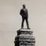 Statue of Cecil Rhodes standing on a tall stone pedestal.