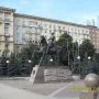 Pyotr Bagration Monument, a bronze equestrian statue on a stone pedestal in a paved plaza with trees and city buildings behind it.