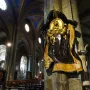Memorial to Maria Raggi mounted on a marble pillar inside a church interior with painted ceilings and pews.