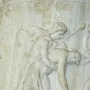 White marble relief on the Borghese Vase showing a draped woman and a nude man pulling at flowing fabric.