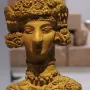 Lady of Ibiza clay figurine with elaborate headdress, necklaces, and decorated dress