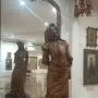 Mephistopheles and Margaretta carved in a tall wooden double-sided statue, with a mirror showing the female figure behind the male figure.