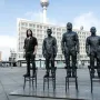 Anything to Say? sculpture figures standing on chairs in Berlin, with the TV Tower in the background.