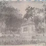 Francisco Pizarro equestrian statue on a stone pedestal in a park with trees and garden beds.