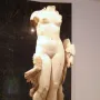 Venus Unica, a headless white stone female nude statue on a rectangular base.
