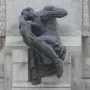 Detail of the Antonio Maceo Monument showing a seated bronze figure in a pensive pose against a carved stone backdrop.