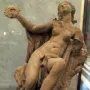 Truth Unveiled by Time sculpture showing a reclining nude female figure holding a disc aloft, with a rough unfinished figure behind her.