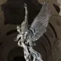 Gloria Victis bronze sculpture showing a winged figure supporting a dying warrior against a marbled wall.