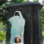 Eternal Silence sculpture, a hooded bronze figure standing before a dark stone slab.
