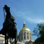 John Brown Gordon statue silhouetted against the Georgia State Capitol dome and blue sky.