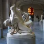 Satyre et bacchante marble sculpture showing two intertwined figures in a museum hall