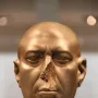 Berlin Green Head, a damaged greenish-brown stone bust with a missing nose and stern expression.