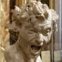 Damned Soul by Gian Lorenzo Bernini, a white marble bust with a screaming anguished face and wild curly hair behind glass.
