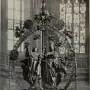 Angelic Salutation, an ornate sculptural ensemble with an angel and woman standing inside a circular wreath, surrounded by small figures and topped by a crowned figure.