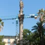 Galceran Marquet Monument with a stone column and standing figure, set in a fountain with bronze marine figures in Barcelona.
