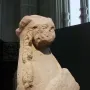 Detail of the Sphinx of Agost showing the eroded human-like head and winged upper body in limestone.
