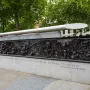 Bronze relief panel on the Battle of Britain Monument showing a pilot in goggles and a gas mask beside scenes of destruction.