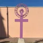 Antimonumenta sculpture in purple, shaped like the Venus symbol with an upright fist on a concrete base.