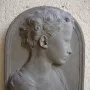 Bust of a Child in profile, showing a curly-haired young figure in draped garments against a dark background.