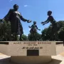 Mary McLeod Bethune Memorial bronze statue of Mary McLeod Bethune with two children reaching toward her.