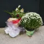 Floral tributes placed before the National Police Memorial, including bouquets and a potted plant with small white flowers.