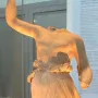 Hebe by Antonio Canova, a headless female statue with one arm raised and draped lower body in a museum display case.