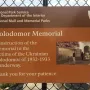 National Park Service sign about Holodomor Memorial construction on a chain-link fence