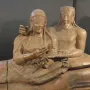 Sarcophagus of the Spouses showing a reclining Etruscan man and woman with gentle smiles and outstretched hands.