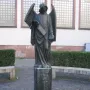Frankfurter Engel sculpture showing a winged figure in flowing robes holding a scroll and a small book or box.