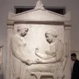 Grave Stele of Hegeso showing two draped women, one seated and examining an object while another stands beside her with an open box.