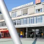 Himmelsstürmer sculpture rising in front of Kassel Hauptbahnhof with the station building in the background.
