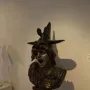 Bronze bust of Bellona with an anguished expression, wearing a helmet and ornate armor with a blue jewel.