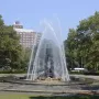 Bailey Fountain with water arcing around dark metallic statues in a circular stone basin.