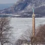Battle Monument at West Point rising above a frozen river with snowy mountains in the background